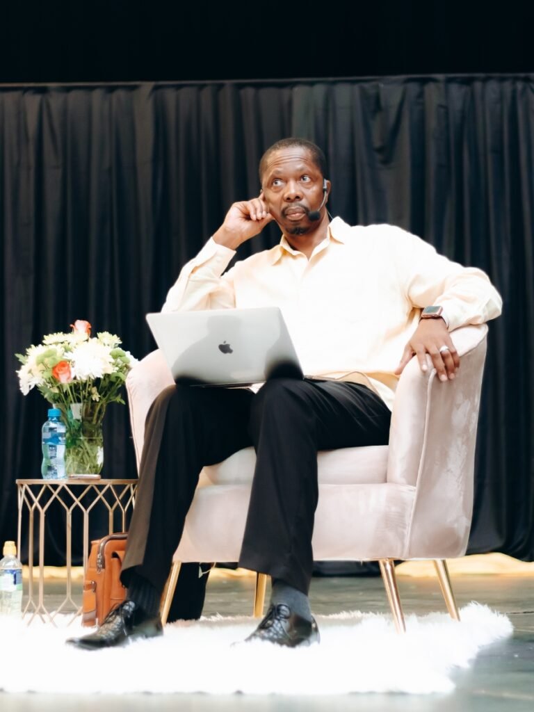 A speaker portrait taken on stage during Professor Tikolo's Masterclass at the COMFESA Symposium.